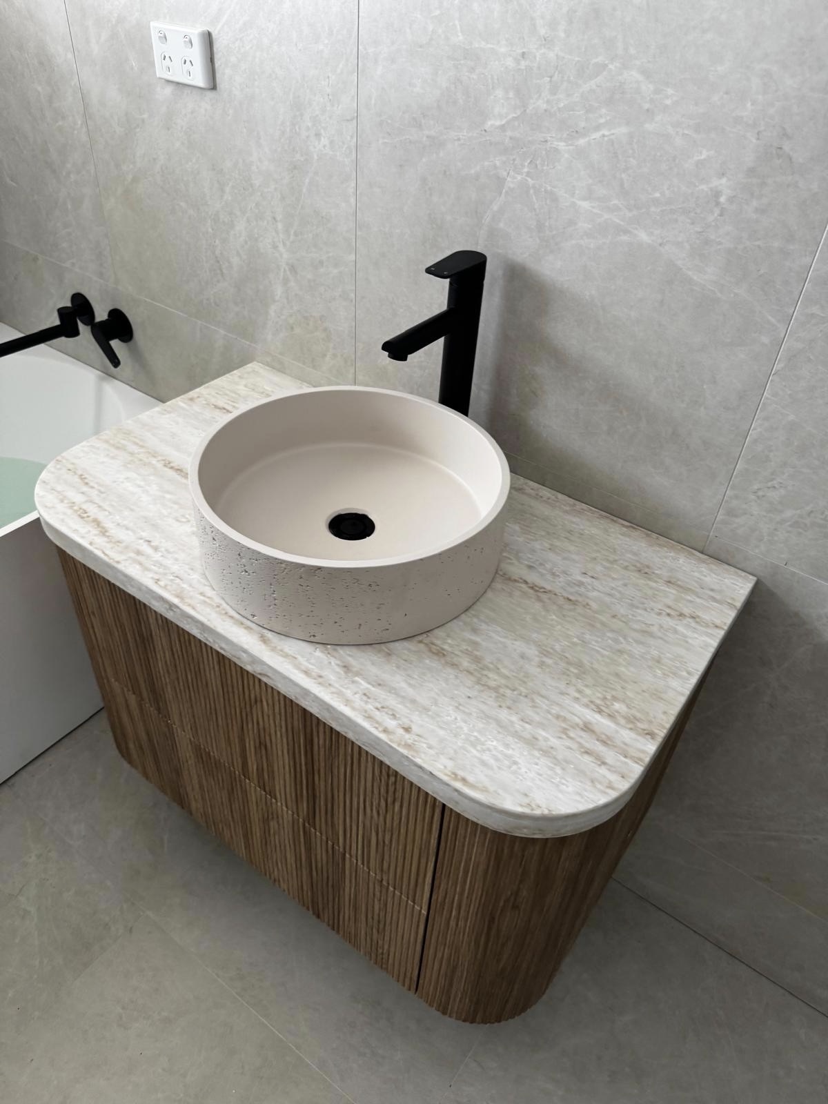 New bathroom vanity with a round basin and black tap installed by One Plumb